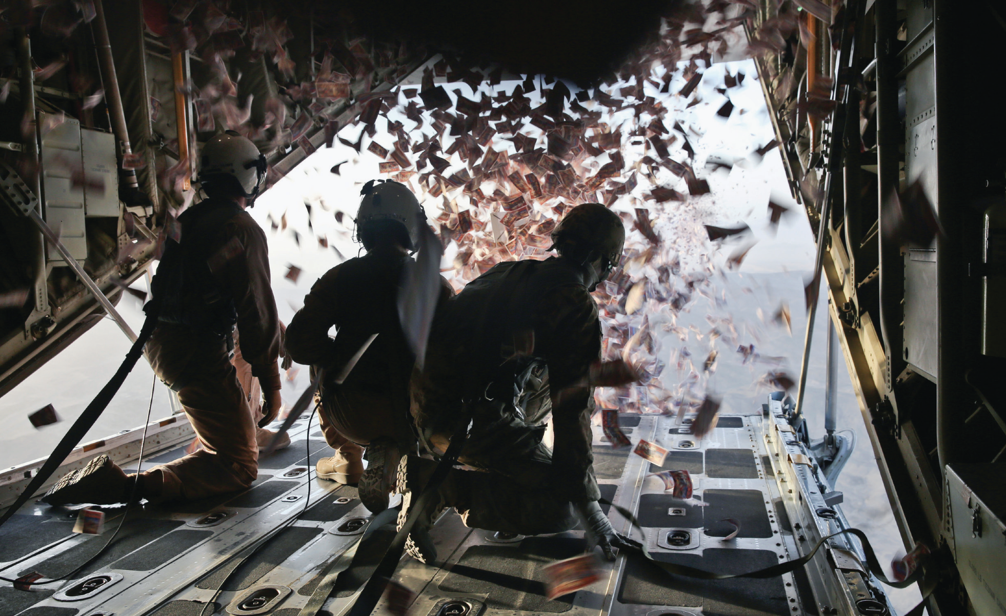 Marines with Marine Aerial Refueler Transport Squadron 252 and Army Sergeant Nijoku Odom, right, intelligence analyst with 303rdPsychological Operations Company, throw leaflets from Marine Corps KC-130J Super Hercules aircraft over southern Afghanistan August 28,2013 (DOD/Demetrius Munnerlyn)